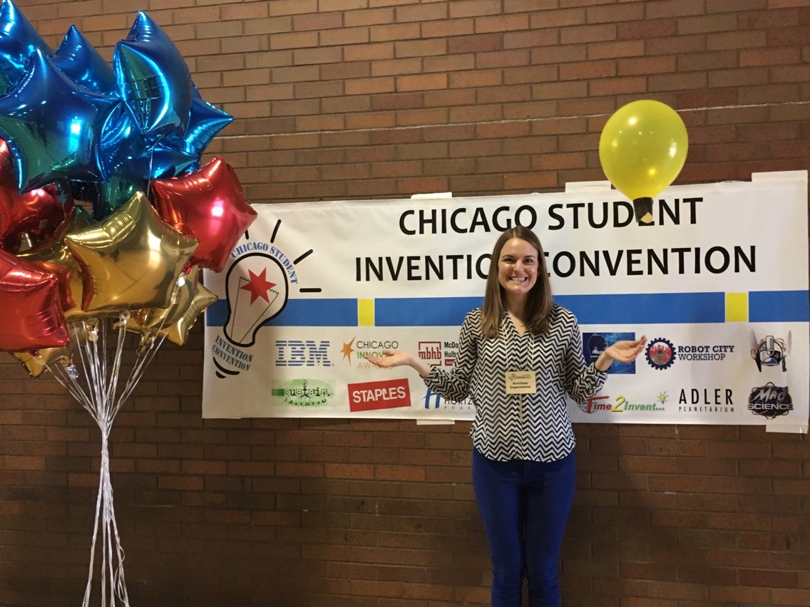 Anneliese Gegenheimer in front of a Chicago Student Invention Convention banner